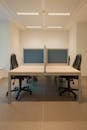 Contemporary office space featuring partitioned desks and ergonomic chairs.